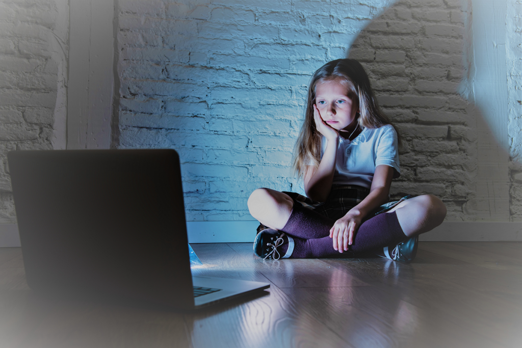 Una niña mirando a la pantalla de un portatil.